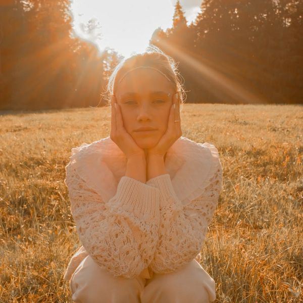 Person meditating in a calm environment with a soft golden glow.